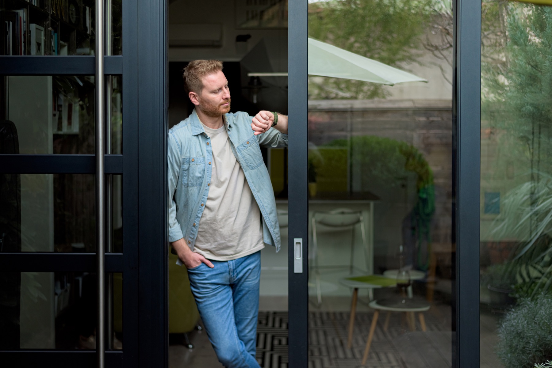 Resident standing beside a bespoke glazed entrance door
