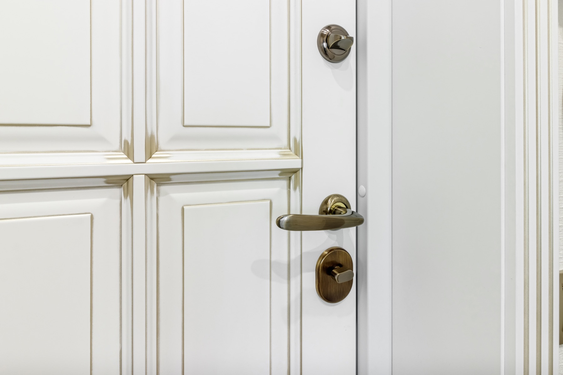 Detailed white entrance door with polished metal lock hardware