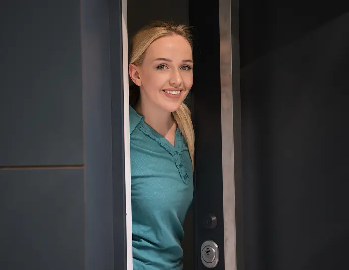 Resident standing beside a bespoke glazed entrance door