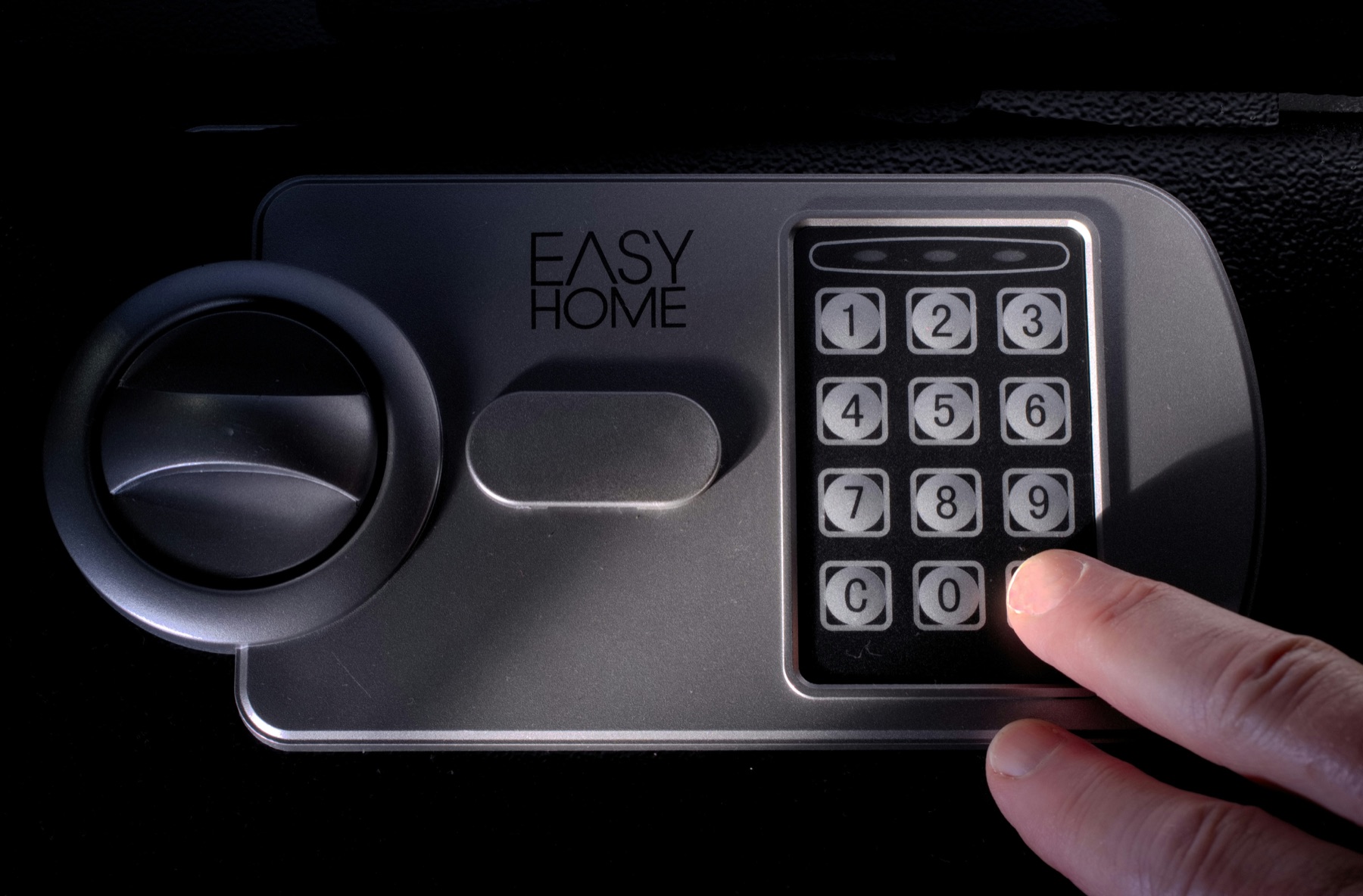 Hand entering a code on a secure electronic lock