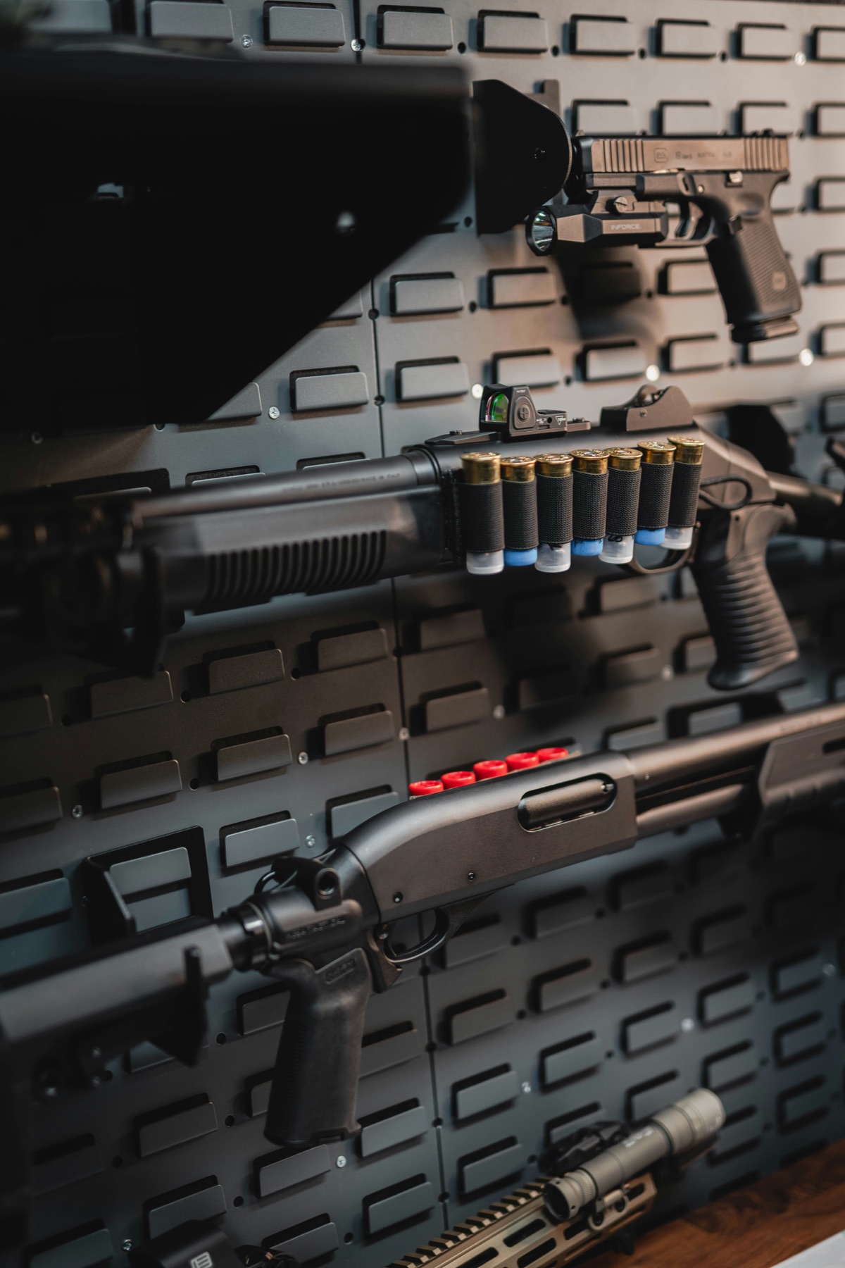 Firearms and ammunition arranged on a secure gun-room wall